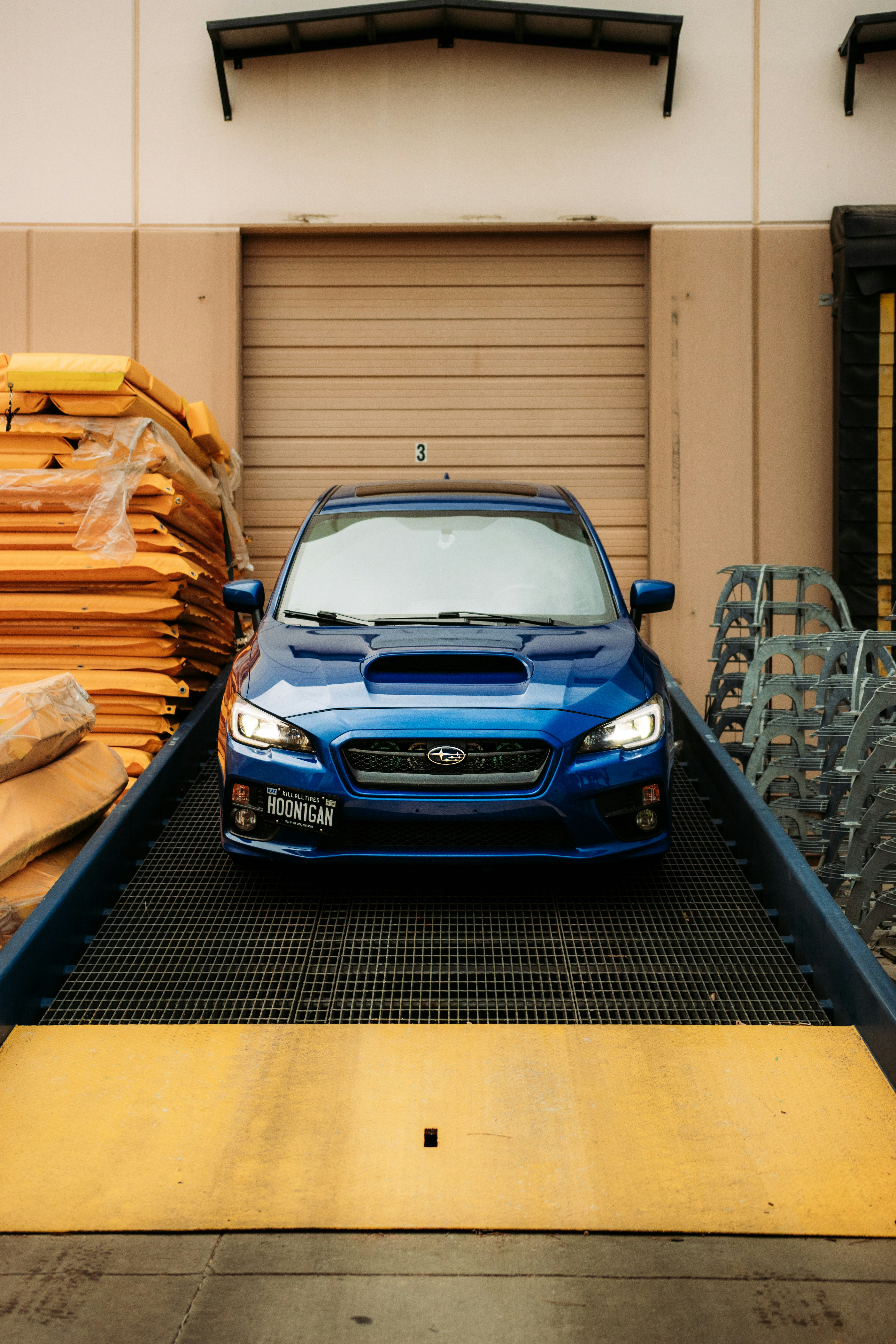 blue bmw m 3 parked beside brown wooden fence